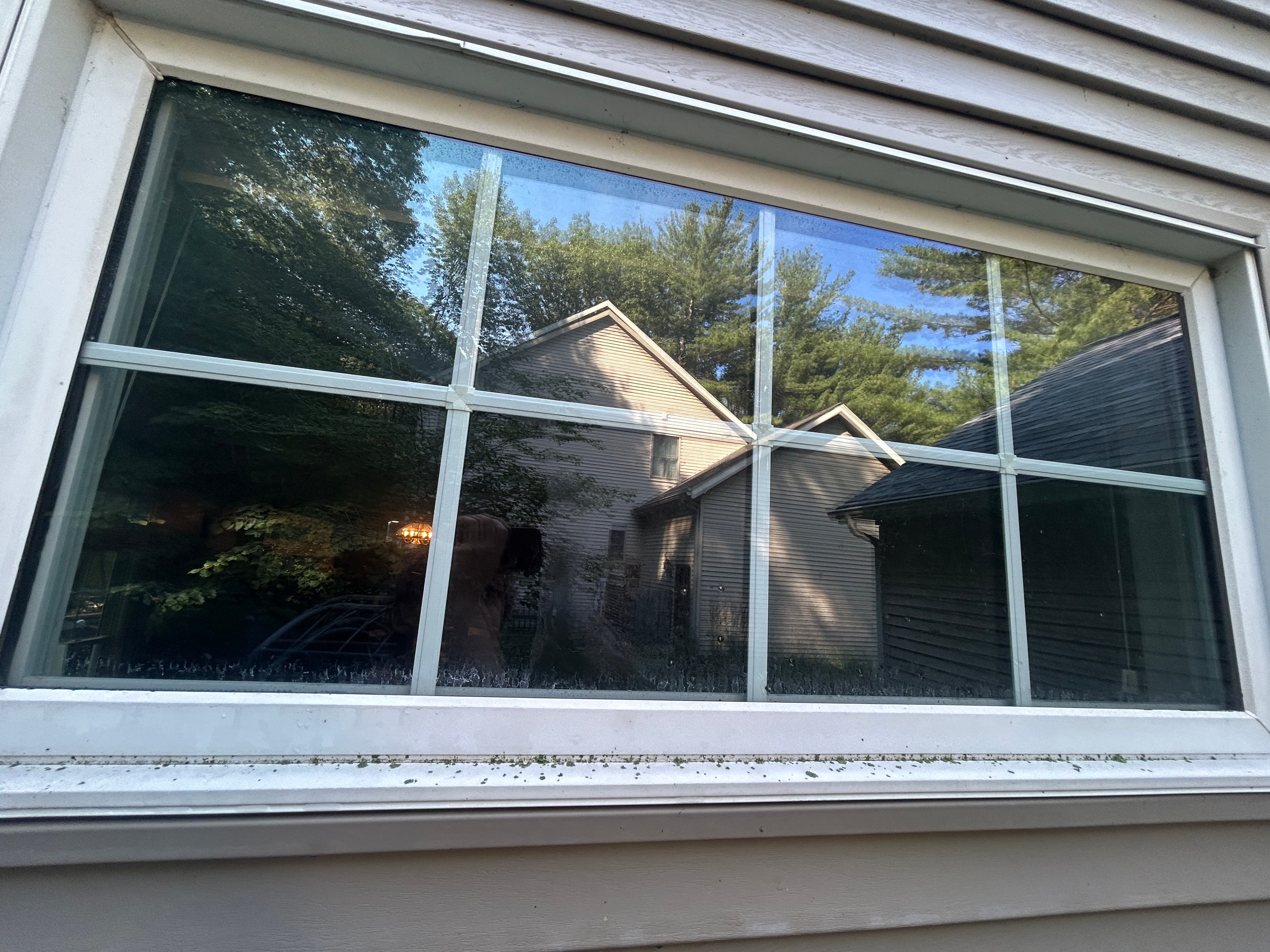 Window glass with visible hard water and mineral spotting before cleaning